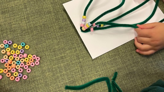 De peuters hebben mooie kerstbomen gemaakt! Door kralen te rijgen aan pijpenragers. 🎄✨